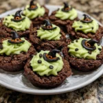 Green-frosted cookie cups with candy bubbles and spooky toppers